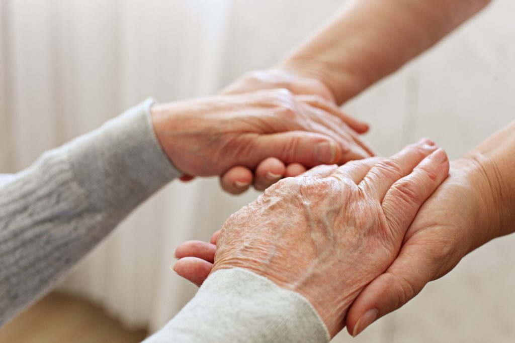 Mains qui tiennent des mains de personne agée