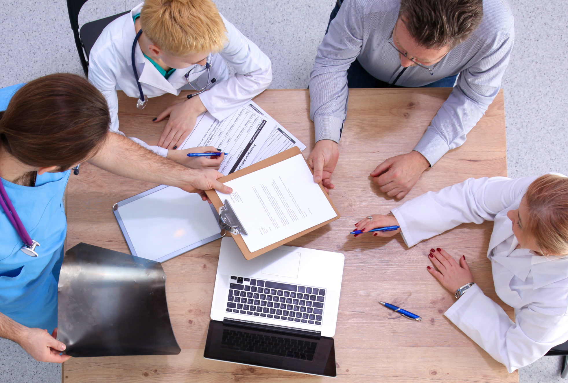 Male and female doctors working on reports in medical office.