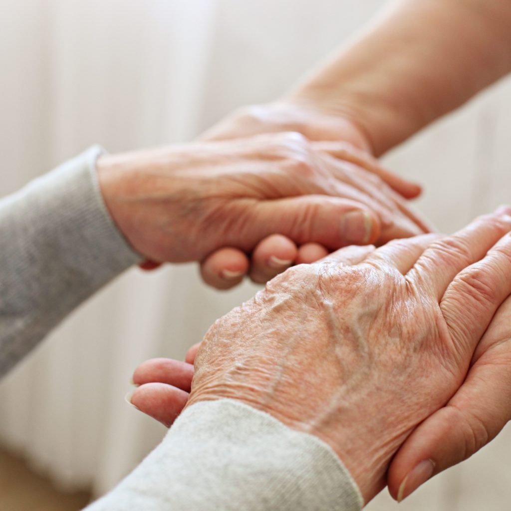 Mains qui tiennent des mains de personne agée